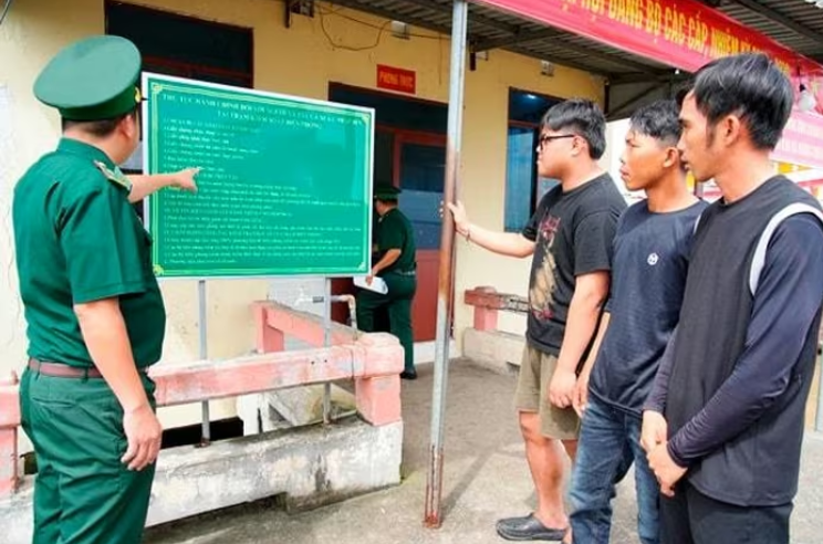 Cán bộ, chiến sĩ đồn Biên phòng Tây Yên (Bộ đội Biên phòng tỉnh An Giang), hướng dẫn ngư dân cập nhật thông tin tàu cá - Ảnh: Tiến Vinh